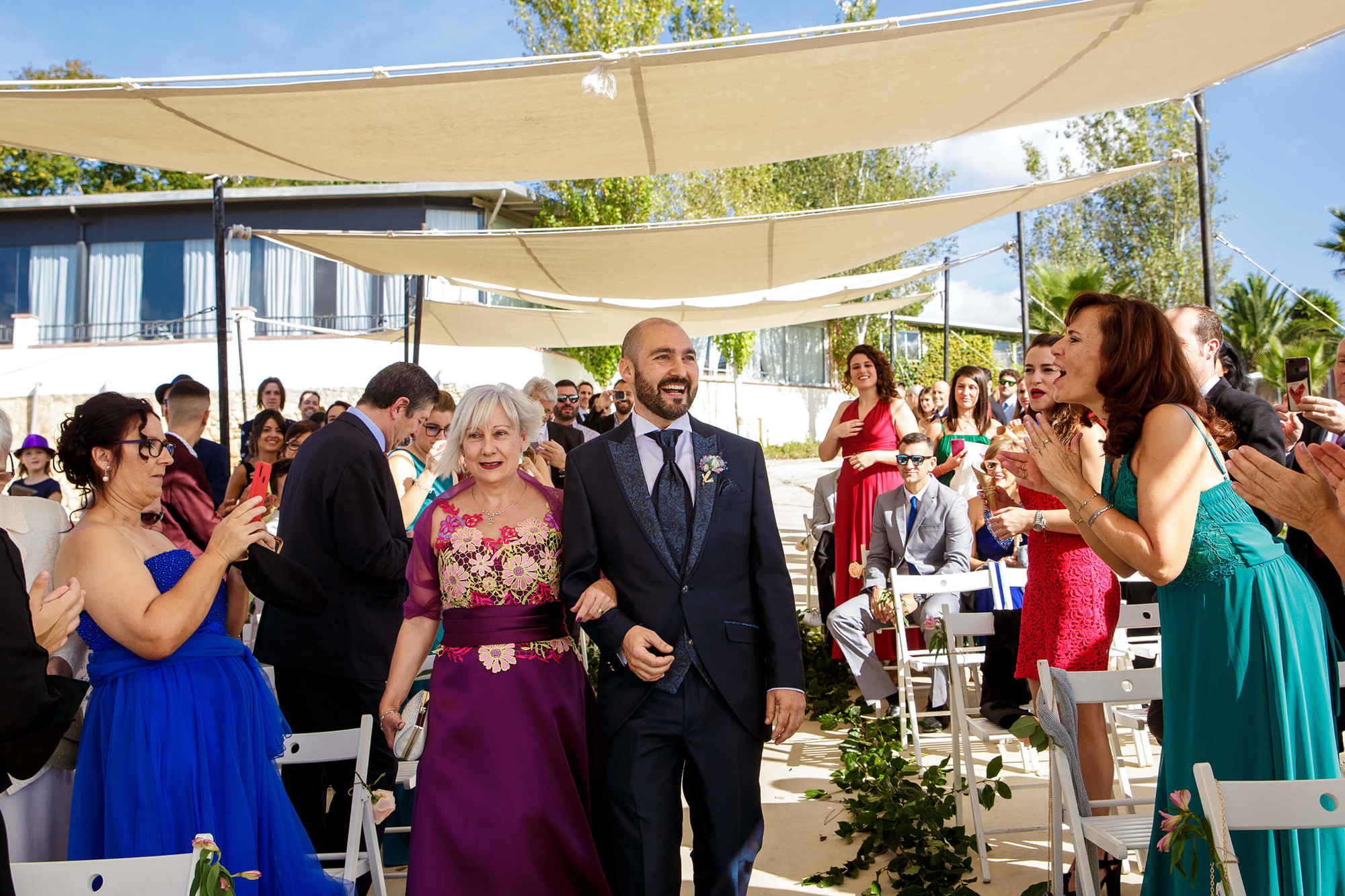 Entrada del novio con su madre a la ceremonia entre viñas en Masia Torreblanca.