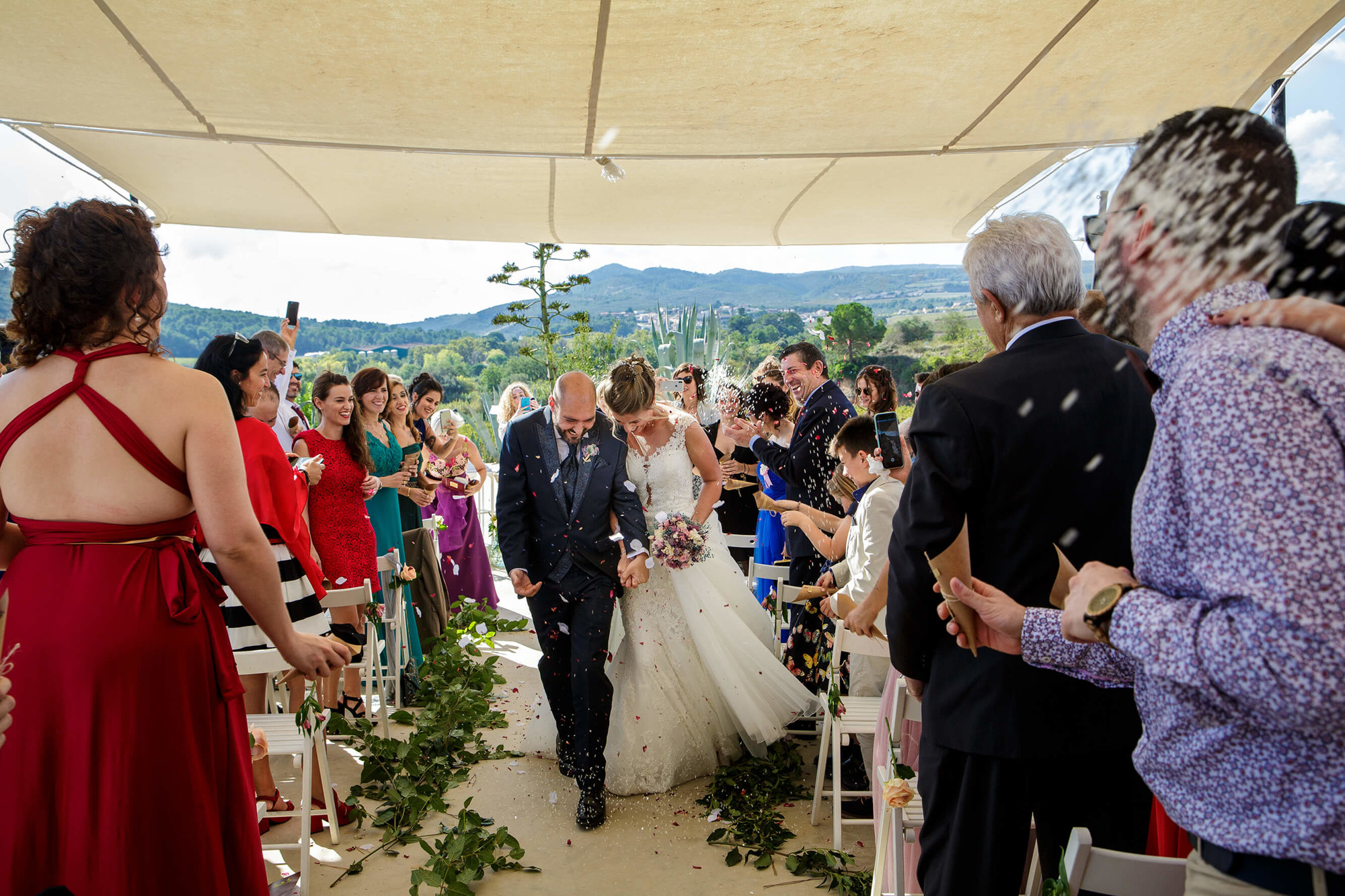 Tiran arroz y pétalos a la salida de la ceremonia de boda en Masia Torreblanca.