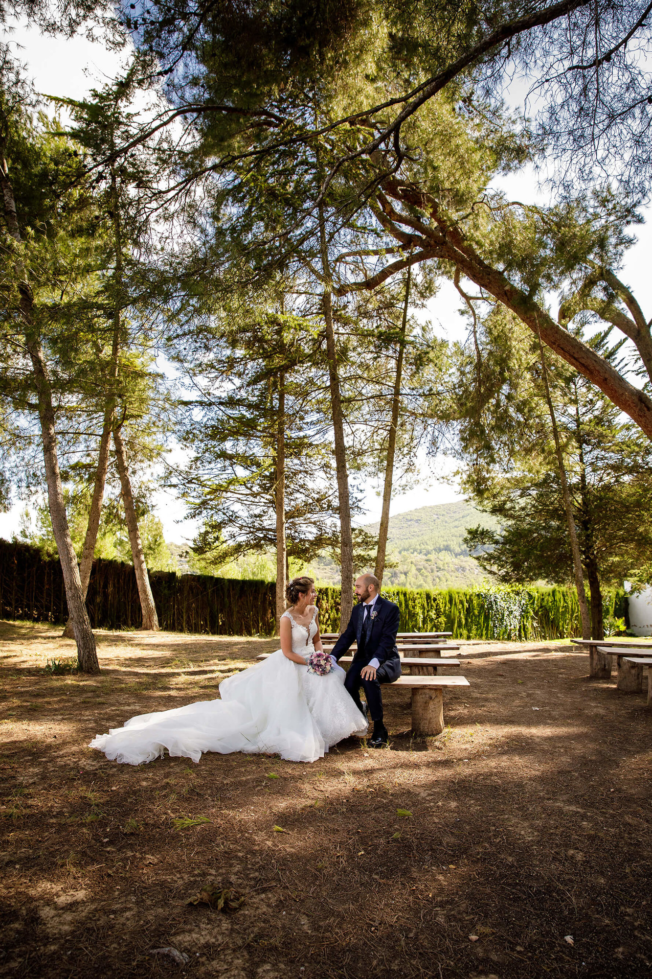 Los novios se sientan en el bosque tras la boda en Masia Torreblanca.