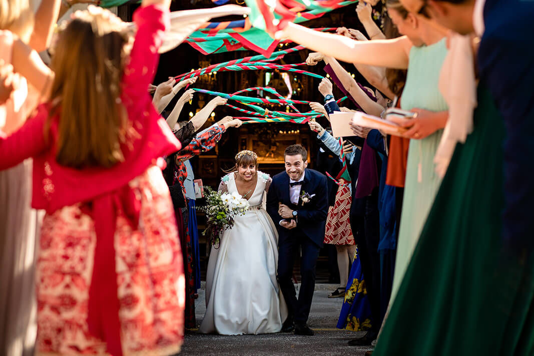 Los novios saliendo de la iglesia del Vinyet en Sitges el día de la boda en Mas Palou.