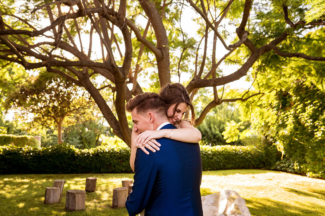 Los novios abrazados en el patio en la boda en Heretat Sabartés.