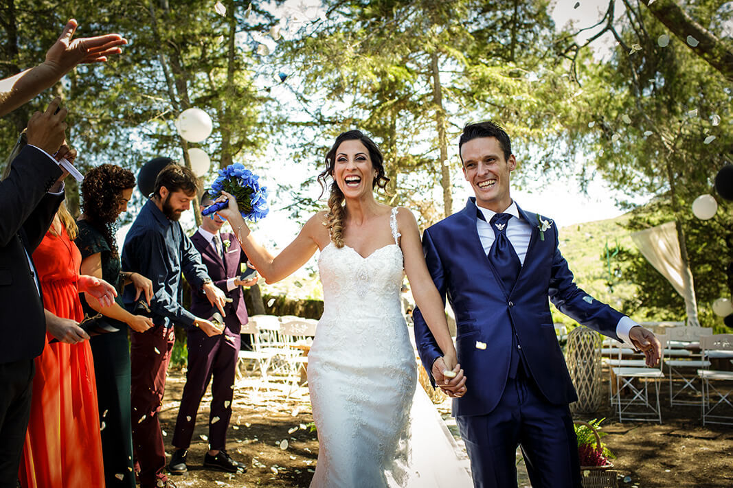 Los novios saliendo de la ceremonia de boda entre los invitados en Masía Torreblanca.