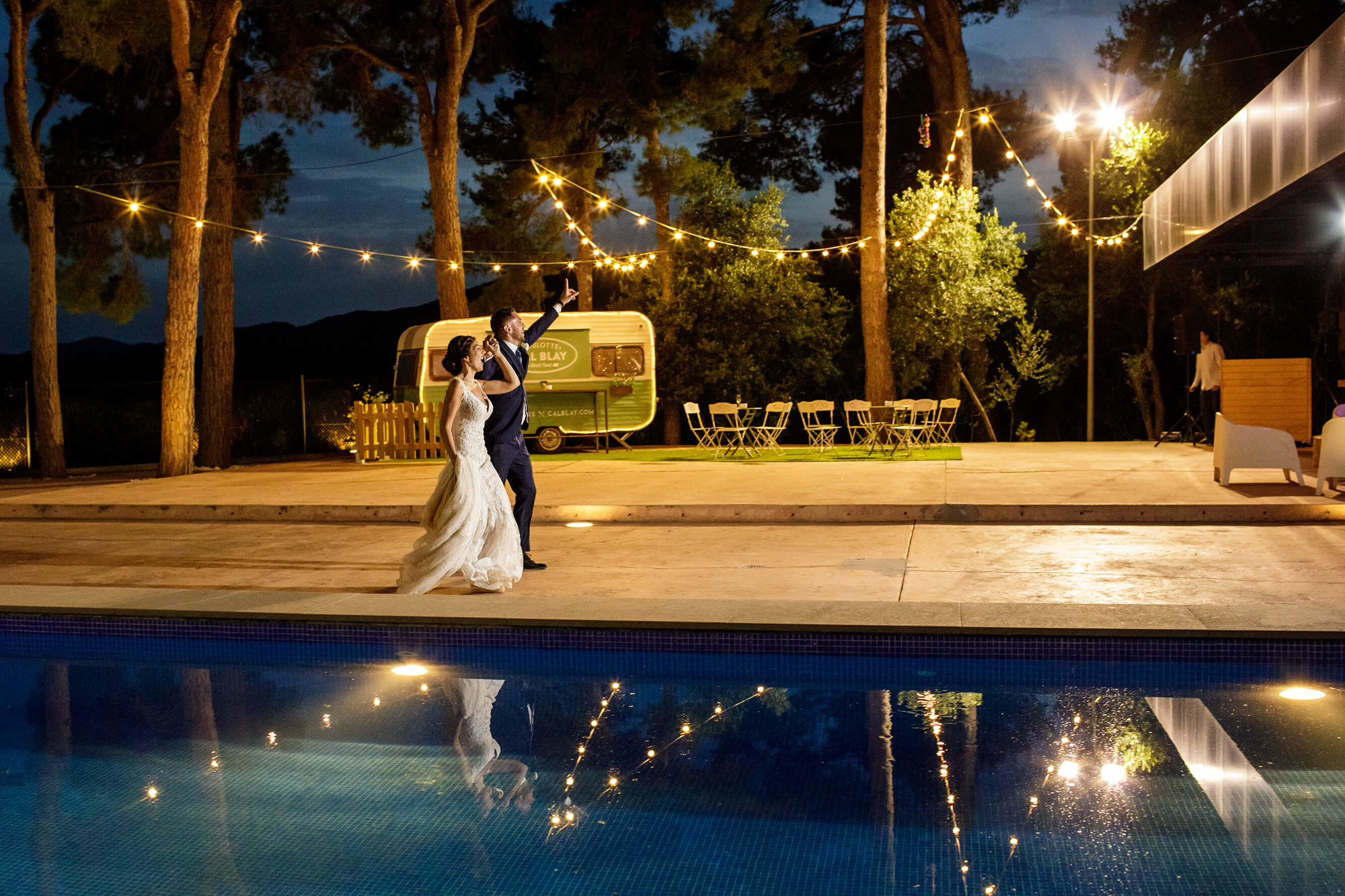 Los novios entran a la cena al lado de la piscina en la boda en Joan Sardà