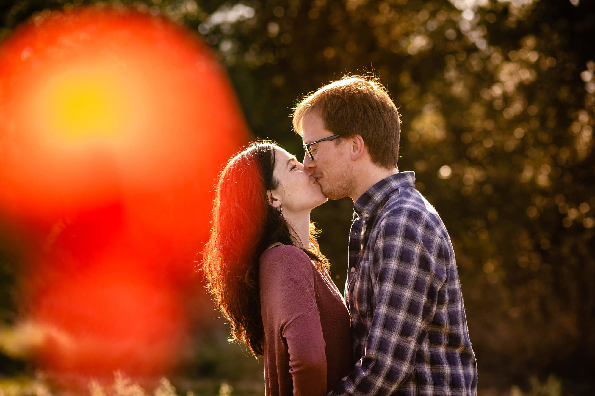 Beso en la sesión preboda en la montaña en un campo de amapolas en el Penedés.