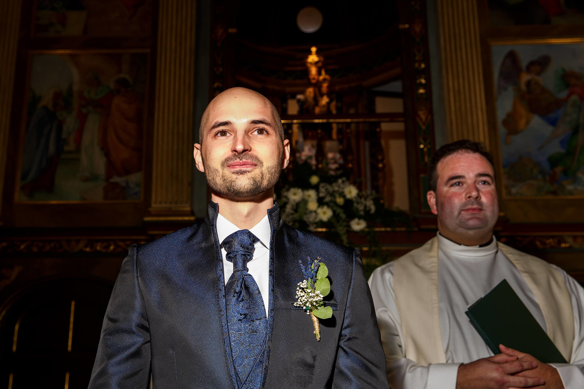 El novio mira a la novia cuando esta entra a la Ermita de la Mare de Déu de Berà.