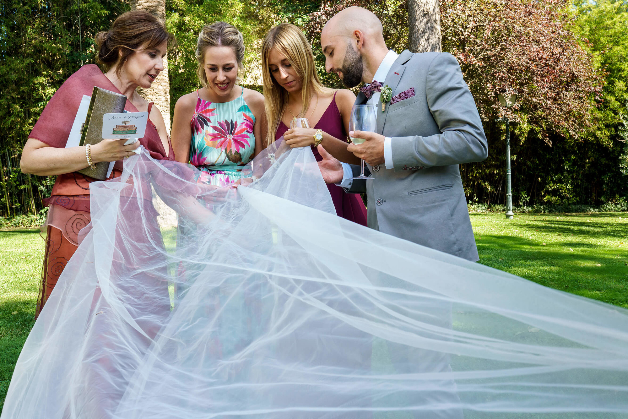4 invitados cogen la cola del vestido de novia.