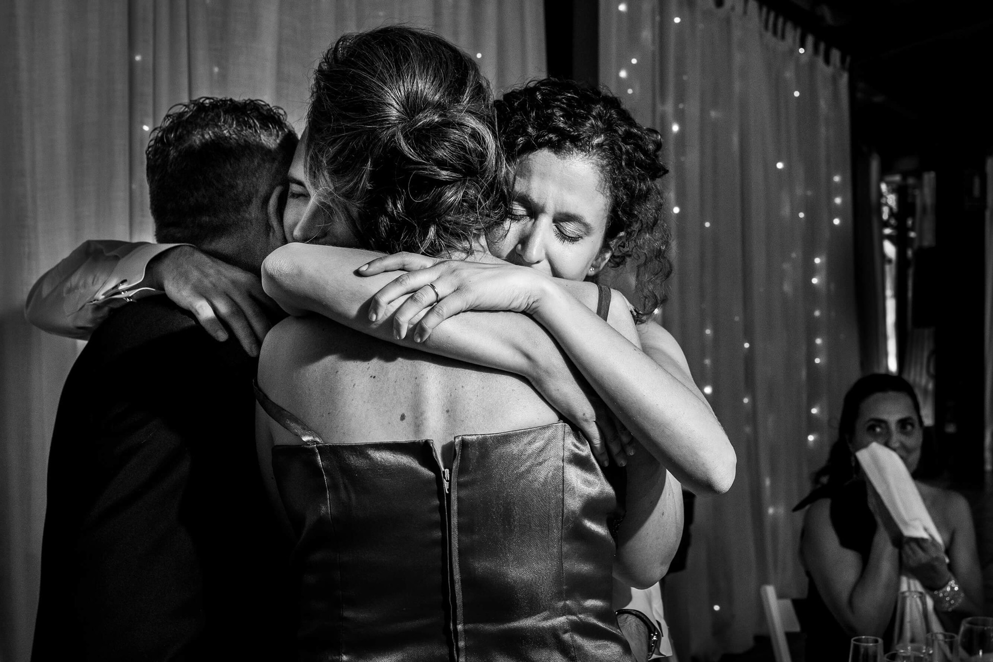 Los novios se abrazan a sus padres emocionados en la boda en Masía Papiol.