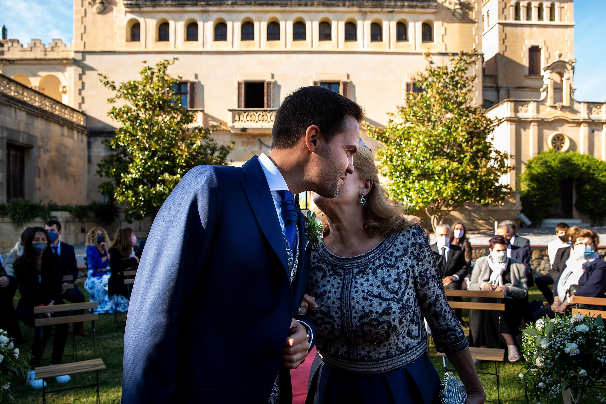 El novio en Heretat Sabartés entra a la ceremonia del brazo de su madre.