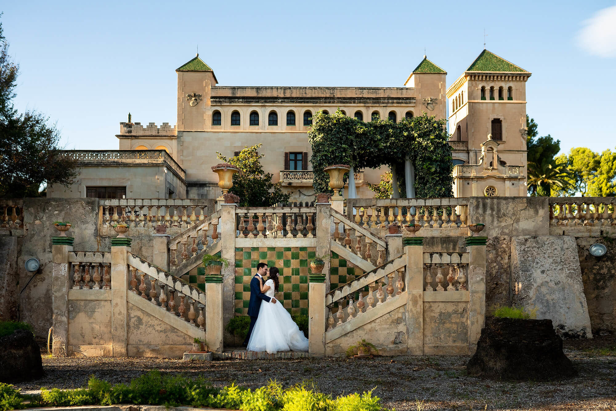 Los novios en la fachada principal el día de la boda en Heretat Sabartés.