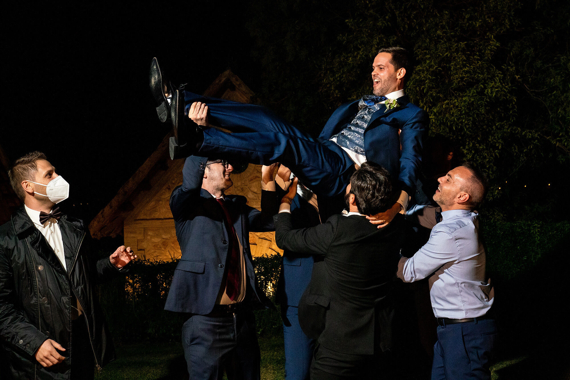 Los amigos levantan al novio en la boda en Heretat Sabartés.