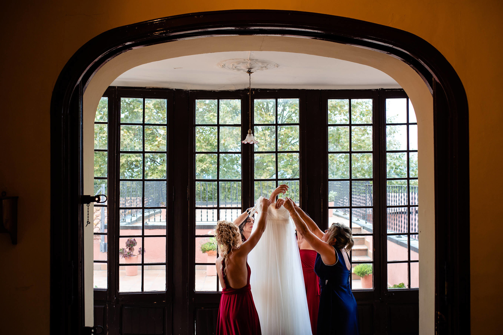 En la boda en la Torre del Gall ayudan a ponerse el vestido de novia.