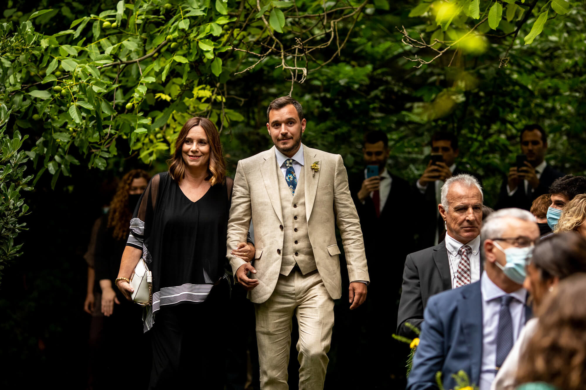 Fotògrafs boda a Mas dels Vivencs pim18 Entrada del nuvi amb la seva mare a la cerimònia.
