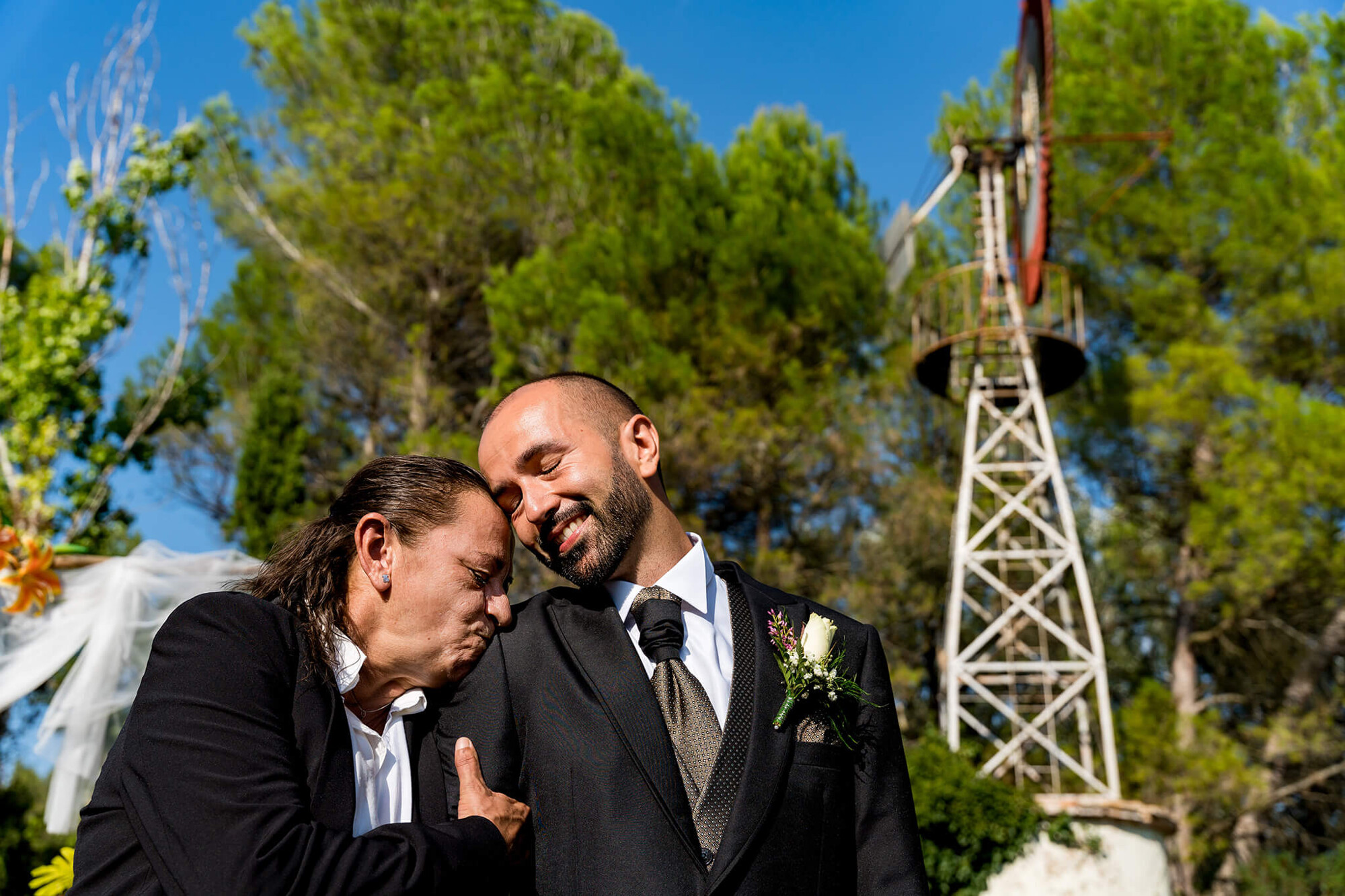 El novio emocionado con su madre viendo la entrada de la novia en Can Macià en Igualada.